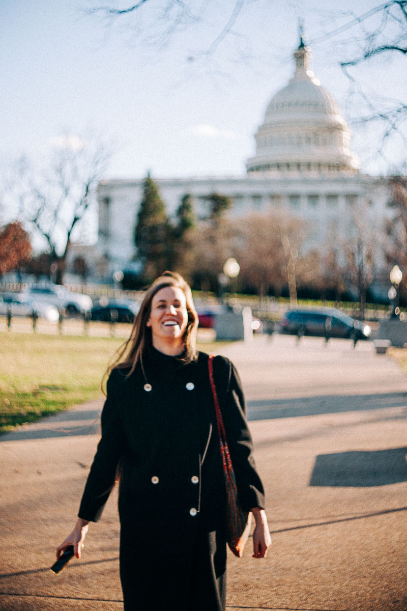 a smiling woman in front of the US Capitol Building
