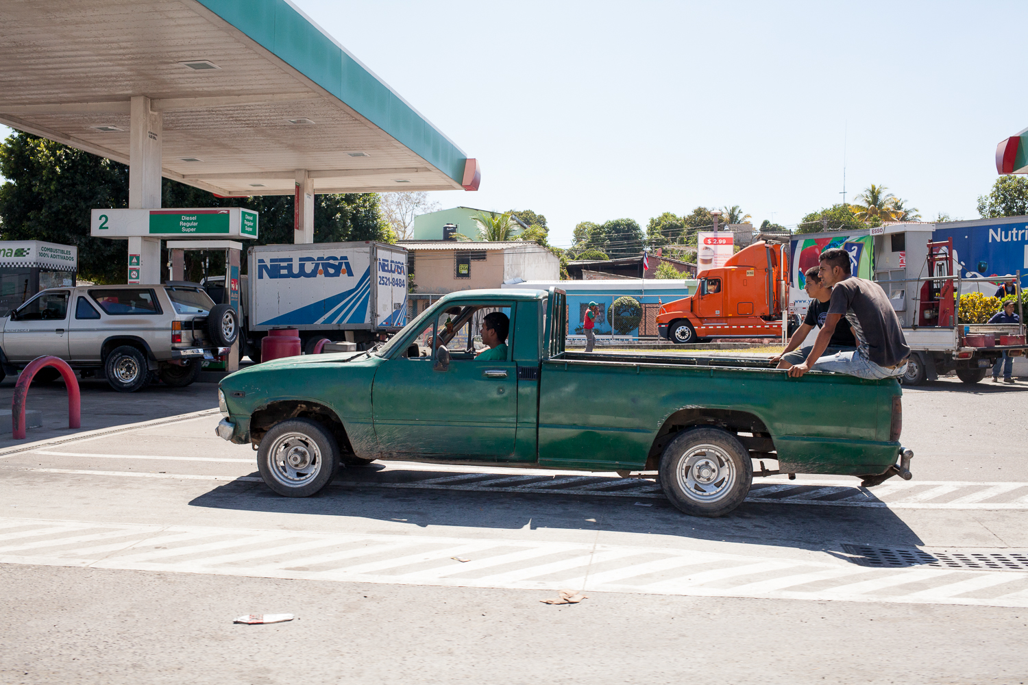 People in a pickup truck at a gas station